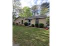 Charming single-story home with a well-maintained lawn and traditional brick facade, set against a backdrop of mature trees at 2884 Haddon Dr, Rex, GA 30273