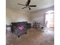 Spacious living room featuring neutral carpet, ceiling fan, and ample natural light from the large arched window at 2884 Haddon Dr, Rex, GA 30273