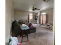Spacious living room featuring neutral carpet, ceiling fan, and ample natural light from the large arched window at 2884 Haddon Dr, Rex, GA 30273