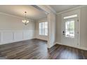 Open living room with hardwood floors, a chandelier, and large windows for natural light at 315 Westfall Ter # 226A, Loganville, GA 30052