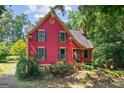 Inviting red two-story home with well-maintained lawn and classic architectural details at 3498 Overland Trl, Ellenwood, GA 30294