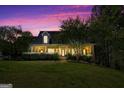 Inviting exterior view of a traditional home with a covered porch, complemented by a beautifully landscaped lawn at dusk at 1561 Aiken Chafin Ln, Mcdonough, GA 30252