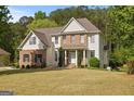 Charming two-story home featuring a combination of brick and siding, complemented by a well-manicured lawn and mature trees at 85 Bloomfield Way, Sharpsburg, GA 30277