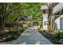View of an elegant home's driveway leading to a covered connecting area next to a manicured lawn at 508 Hastings Dr, Peachtree City, GA 30269