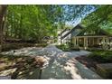 Home featuring lush landscaping, a covered connecting area, and a long driveway in a wooded setting at 508 Hastings Dr, Peachtree City, GA 30269