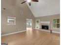 Spacious living room features a fireplace, a ceiling fan, and wood flooring at 506 Brewer Dr, Locust Grove, GA 30248