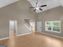 Open-concept living room with wood floors, a staircase, and a front entry door at 506 Brewer Dr, Locust Grove, GA 30248