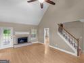 Bright living room featuring a fireplace, a ceiling fan, and a staircase at 506 Brewer Dr, Locust Grove, GA 30248