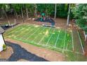 Aerial view of backyard with football field, playground and wooded surroundings at 870 Rutherford Dr, Dacula, GA 30019