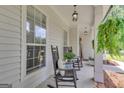Relaxing front porch with rocking chairs and ferns, creating a welcoming entrance at 140 Laurel Lake Rd, Tyrone, GA 30290