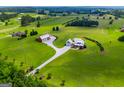 Expansive aerial view showcasing the modern farmhouse, barn, and surrounding lush green landscape at 385 Liberty Church Rd, Carrollton, GA 30116