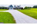 Inviting two-car garage and covered porch entrance with beautiful gravel driveway leading to a modern farmhouse at 385 Liberty Church Rd, Carrollton, GA 30116