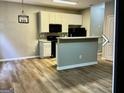 Cozy kitchen featuring white cabinets, a breakfast bar, and modern black appliances for convenient cooking at 5057 Windsor Forrest Lane, Atlanta, GA 30349