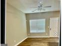Bright living room featuring hardwood floors, a ceiling fan, and a window with blinds for natural light at 5057 Windsor Forrest Lane, Atlanta, GA 30349