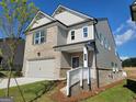 The side of this home is gray vinyl siding and gray brick, featuring a two-car garage at 35 Fraser Ln # 123B, Auburn, GA 30011
