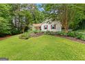 Traditional style home featuring mature trees, a lush lawn and brown window shutters at 205 N Strathmore Dr, Sharpsburg, GA 30277