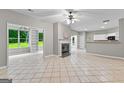 Open-concept living area with fireplace, tile floors, and natural light from large windows at 205 N Strathmore Dr, Sharpsburg, GA 30277