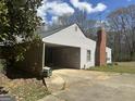 Exterior view of home showcasing carport, brick chimney, and a mature tree at 2534 Highway 155 N, Mcdonough, GA 30252