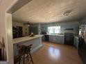 Eat-in kitchen with blue cabinetry, black appliances, and breakfast bar area at 2534 Highway 155 N, Mcdonough, GA 30252