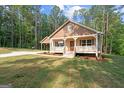 Home with a covered porch and matching carport, set on a beautiful lot with mature trees at 55 Etheridge Rd, Temple, GA 30179