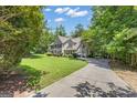 Long driveway leading to a well-maintained home with lush green lawn at 15 Skipton Ct, Sharpsburg, GA 30277