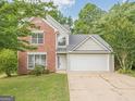 Charming two-story home featuring a brick facade, attached two-car garage, and well-manicured lawn at 2576 Abbotts Glen Nw Dr, Acworth, GA 30101