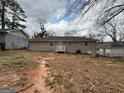 A view of the backyard featuring a house, partial patio, and a detached garage at 1068 Longshore Dr, Decatur, GA 30032