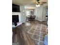 Open-concept living and dining area with wood floors, fireplace, and a modern ceiling fan at 517 Pebble Pt, Loganville, GA 30052
