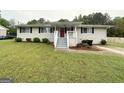 Cozy single-story home featuring a covered front porch, well-maintained lawn, and classic window shutters at 64 Gregory Ct, Dallas, GA 30157