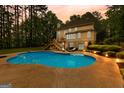 Backyard oasis featuring a large in-ground pool, a patio, and mature trees at 155 Carrolls Way, Fayetteville, GA 30215