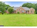 A charming brick home with a well-manicured lawn and beautiful landscaping at 344 Mckibben Dr, Locust Grove, GA 30248