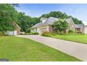 A well-maintained home with a brick exterior, a wide driveway, and a two-car garage at 344 Mckibben Dr, Locust Grove, GA 30248