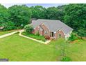 Aerial view of a well-maintained brick home with a lush green lawn and mature trees at 344 Mckibben Dr, Locust Grove, GA 30248