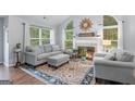 Comfortable living room featuring a fireplace, large windows with natural light, and stylish decor at 320 Cobb Ct, Hampton, GA 30228
