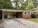 Close-up of brick home featuring covered parking and well maintained yard at 1486 Harbour Oaks Rd, Tucker, GA 30084