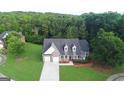 Aerial view of a beautiful home with a large front lawn in a lush, wooded neighborhood at 185 Stewart Glen Dr, Covington, GA 30014
