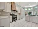 Bright kitchen featuring custom white cabinets, modern appliances, and tile flooring at 185 Newfield Dr, Tyrone, GA 30290