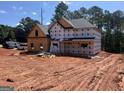 New two-story home under construction featuring black roof and a charming covered front porch at 140 Wilson Drive, Mcdonough, GA 30252
