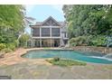 A view of the pool with a small waterfall and a screened-in porch in the background at 505 Lighthouse Ln, Peachtree City, GA 30269
