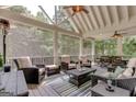 A screened porch with comfortable seating, ceiling fans, and views of the surrounding trees at 505 Lighthouse Ln, Peachtree City, GA 30269