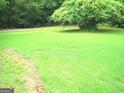 The well maintained lawn, bordered with brick, and mature trees create a serene outdoor space at 225 Long Creek Dr, Covington, GA 30016