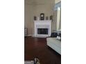Inviting living room features a white mantle over a fireplace and hardwood floors at 85 Bermuda Run Dr, Covington, GA 30016
