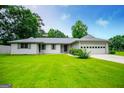 Charming single-story home features a lush green lawn, a two-car garage, and gray window shutters at 65 Pine Haven Ct, Carrollton, GA 30116