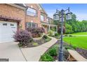 Beautiful brick home featuring lush landscaping along walkway leading to the front porch at 52 Olivia Ct, Palmetto, GA 30268