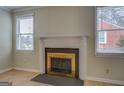 Close-up of the fireplace with a white mantle and metallic gold fireplace screen at 4131 Carroll Sw St, Covington, GA 30014