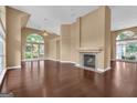 Spacious living room featuring dark hardwood floors, a fireplace, and many large windows at 111 Kenton Pl, Peachtree City, GA 30269