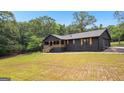 Beautiful black home with a covered porch in a peaceful, green setting. Home boasts craftsman details and modern design at 8129 S Giles Rd, Douglasville, GA 30135