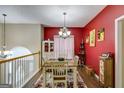 Elegant dining room with a traditional table setting, accented by a bright red wall and classic decor at 129 Onyx Ct, Carrollton, GA 30116