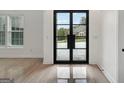 Bright foyer with large windows and sleek tiled flooring provides a modern and inviting entrance at 4186 Matisse Ln, Fairburn, GA 30213