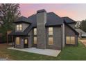 Charming rear exterior featuring a brick facade, well-maintained lawn, and a cozy outdoor space perfect for relaxation at 4186 Matisse Ln, Fairburn, GA 30213
